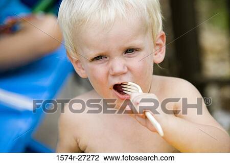 Close-up of a shirtless boy biting folk View Large Photo Image Stock Image - Close-up of a shirtless boy biting folk. Fotosearch