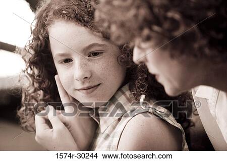 Close-up of a smiling girl with her mother View Large Photo Image Picture - Close-up of a smiling girl with her mother. Fotosearch