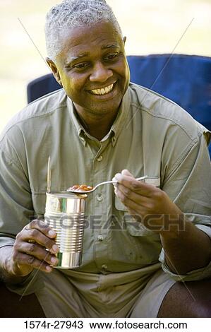 Close-up of a smiling mature man holding spoon View Large Photo Image Stock Image - Close-up of a smiling mature man holding spoon. Fotosearch