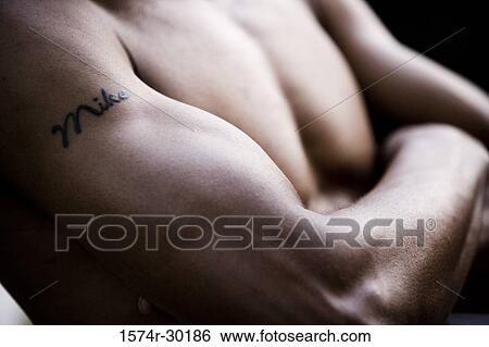 Close-up of a tattoo on an arm of a shirtless man with his arms crossed View Large Photo Image Stock Photograph - Close-up of a tattoo on an arm of a shirtless man with his arms crossed. Fotosearch