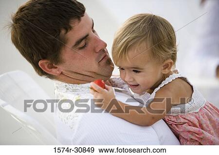 Stock Photo - Close-up of a young man holding his daughter. Fotosearch