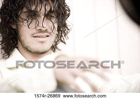 Close-up of a young man looking away View Large Photo Image Stock Photo - Close-up of a young man looking away. Fotosearch