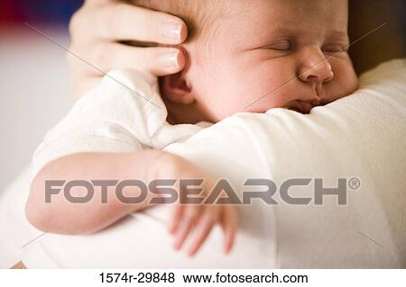 Close-up of a young woman holding her baby View Large Photo Image Stock Photo - Close-up of a young woman holding her baby. Fotosearch