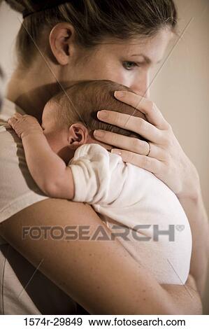 Close-up of a young woman holding her baby View Large Photo Image Stock Photo - Close-up of a young woman holding her baby. Fotosearch
