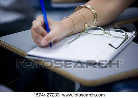 Stock Image - Close-up of human hand writing in a notebook. Fotosearch
