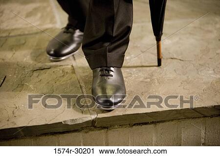 Close-up of man's shoes on the tile flooring View Large Photo Image Stock Image - Close-up of man's shoes on the tile flooring. Fotosearch