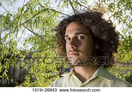 Close-up of young man with curly hair staring View Large Photo Image Stock Image - Close-up of young man with curly hair staring. Fotosearch