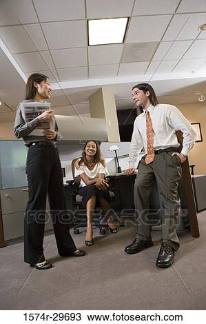 Stock Image - Colleagues discussing in an office. Fotosearch