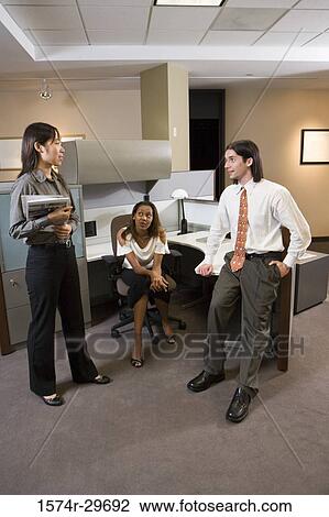 Stock Image - Colleagues discussing in office. Fotosearch