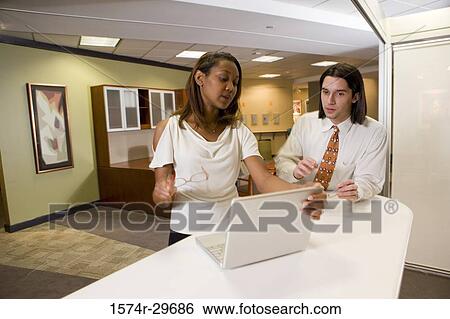Colleagues discussing in office View Large Photo Image Stock Photograph - Colleagues discussing in office. Fotosearch