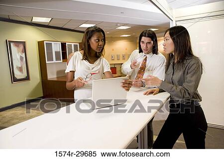 Colleagues discussing in office View Large Photo Image Stock Photography - Colleagues discussing in office. Fotosearch