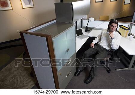 Stock Image - Contemplative businessman sitting in an office. Fotosearch
