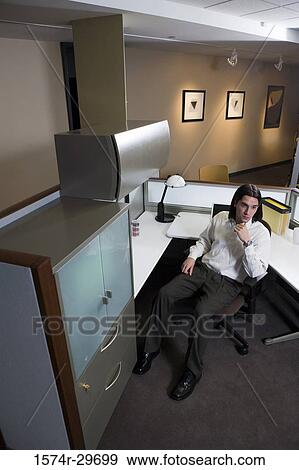Contemplative businessman sitting in an office View Large Photo Image Stock Photo - Contemplative businessman sitting in an office. Fotosearch
