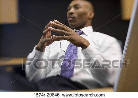 Contemplative businessman sitting in an office View Large Photo Image Stock Photograph - Contemplative businessman sitting in an office. Fotosearch