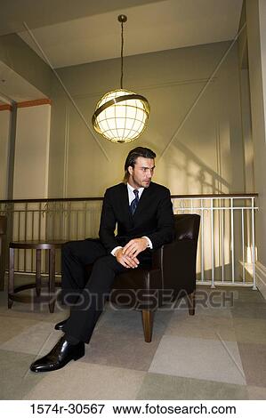 Contemplative businessman sitting on armchair in an office View Large Photo Image Stock Photo - Contemplative businessman sitting on armchair in an office. Fotosearch