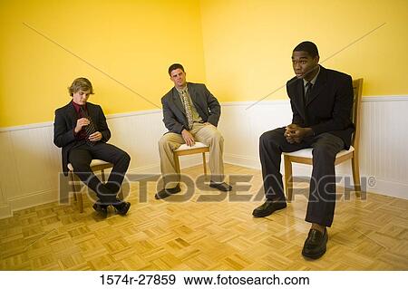 Contemplative businessmen sitting on chairs in an office View Large Photo Image Stock Photo - Contemplative businessmen sitting on chairs in an office. Fotosearch
