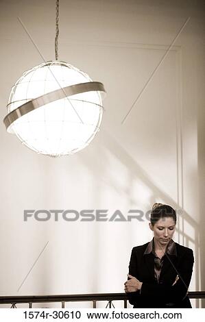 Stock Image - Contemplative businesswoman looking down. Fotosearch