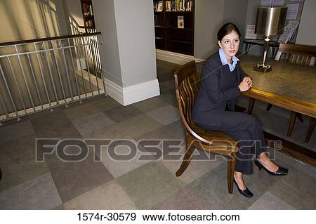 Contemplative businesswoman sitting on chair in an office View Large Photo Image Stock Photo - Contemplative businesswoman sitting on chair in an office. Fotosearch