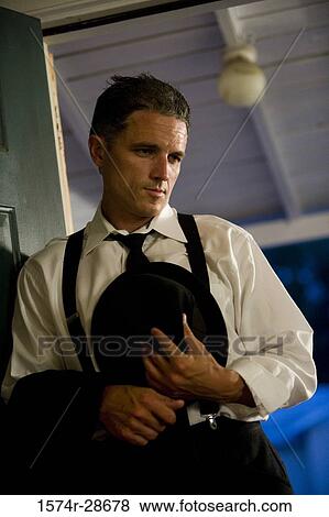 Stock Photo - Contemplative mid adult man leaning by door. Fotosearch