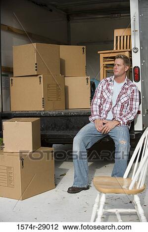 Contemplative mid adult man sitting by a moving van View Large Photo Image Stock Image - Contemplative mid adult man sitting by a moving van. Fotosearch
