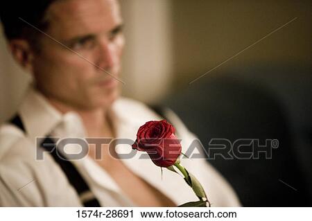 Contemplative mid adult man with rose in foreground View Large Photo Image Stock Image - Contemplative mid adult man with rose in foreground. Fotosearch