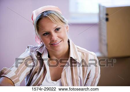 Contemplative mid adult woman sitting with hand on knee by cardboard boxes View Large Photo Image Stock Image - Contemplative mid adult woman sitting with hand on knee by cardboard boxes. Fotosearch