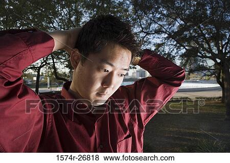 Contemplative young businessman with hands behind head at park View Large Photo Image Stock Photo - Contemplative young businessman with hands behind head at park. Fotosearch