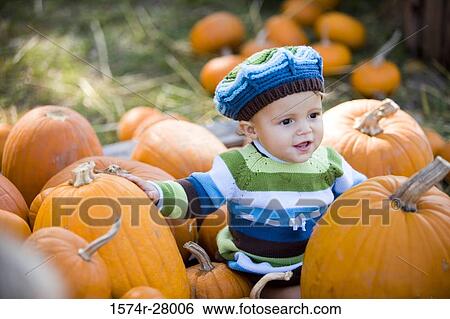 Cute boy in warm clothing sitting amid pumpkins View Large Photo Image Stock Photograph - Cute boy in warm clothing sitting amid pumpkins. Fotosearch