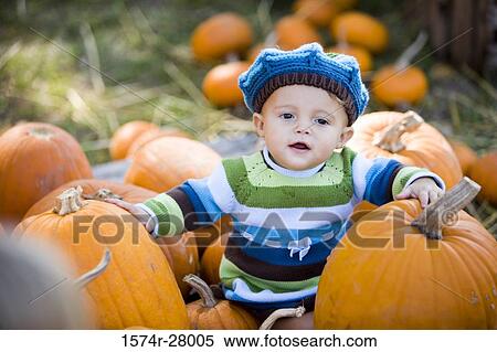 Cute boy in warm clothing sitting amid pumpkins View Large Photo Image Stock Photography - Cute boy in warm clothing sitting amid pumpkins. Fotosearch