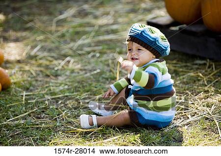 Cute boy in warm clothing sitting on hay View Large Photo Image Picture - Cute boy in warm clothing sitting on hay. Fotosearch