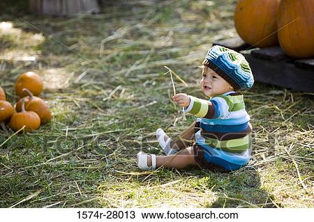 Cute boy in warm clothing sitting on hay View Large Photo Image Stock Image - Cute boy in warm clothing sitting on hay. Fotosearch