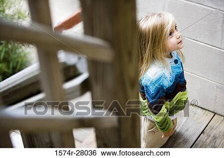 Cute girl in warm clothing standing on staircase View Large Photo Image Stock Photograph - Cute girl in warm clothing standing on staircase. Fotosearch