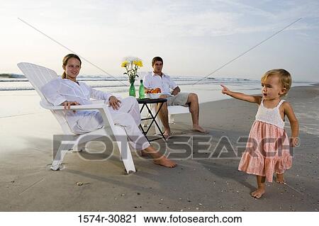 Stock Image - Family relaxing on the beach. Fotosearch
