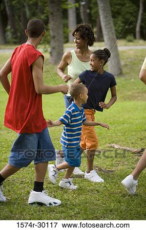 Stock Photo - Family running and looking away at park. Fotosearch