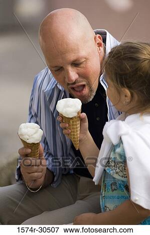 Stock Photo - Father and daughter eating ice cream cones. Fotosearch