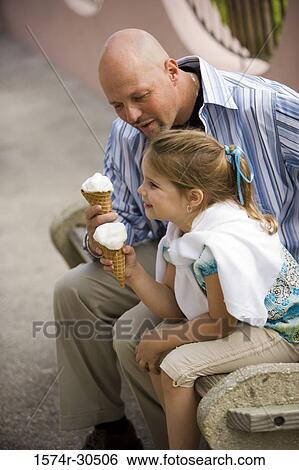 Father and daughter sitting on a bench and holding ice cream cones View Large Photo Image Stock Photograph - Father and daughter sitting on a bench and holding ice cream cones. Fotosearch