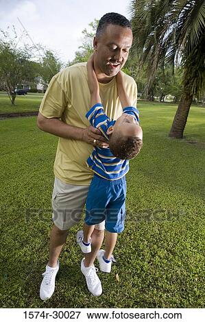 Father carrying his son at park View Large Photo Image Stock Photo - Father carrying his son at park. Fotosearch