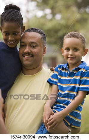 Father holding their children at park View Large Photo Image Picture - Father holding their children at park. Fotosearch