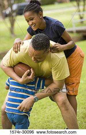 Stock Photograph - Father playing with their children at park. Fotosearch