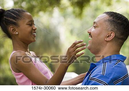 Stock Image - Father smiling face to face with his daughter. Fotosearch