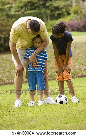 Father standing with their children at park View Large Photo Image Picture - Father standing with their children at park. Fotosearch