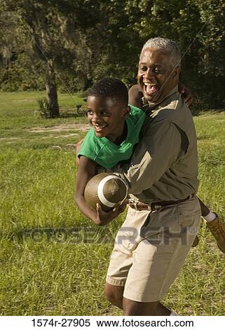 Father with his son holding football at forest View Large Photo Image Stock Photography - Father with his son holding football at forest. Fotosearch