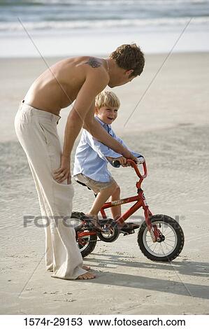 Father with his son riding a bicycle at the beach View Large Photo Image Stock Image - Father with his son riding a bicycle at the beach. Fotosearch