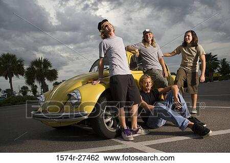 Stock Image - Friends by a car at the parking area. Fotosearch