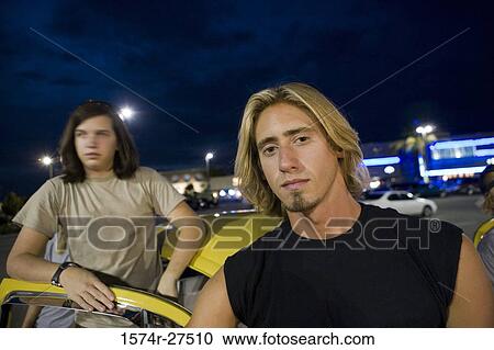 Stock Image - Friends by a car at the parking area. Fotosearch