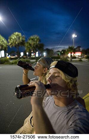 Friends drinking by a car at the parking area View Large Photo Image Stock Photograph - Friends drinking by a car at the parking area. Fotosearch