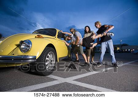 Friends enjoying music by a car at the parking area View Large Photo Image Stock Photo - Friends enjoying music by a car at the parking area. Fotosearch