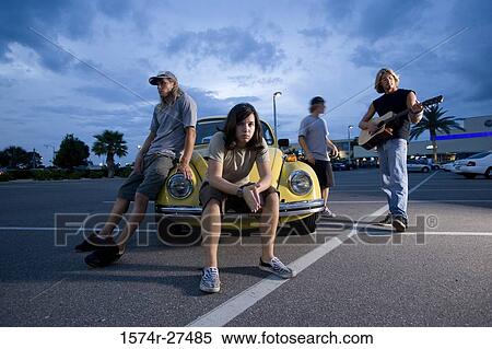 Friends enjoying music by a car at the parking area View Large Photo Image Stock Photography - Friends enjoying music by a car at the parking area. Fotosearch