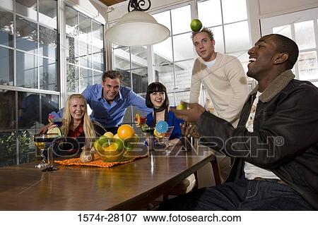 Friends enjoying their drinks in dining room View Large Photo Image Stock Photo - Friends enjoying their drinks in dining room. Fotosearch