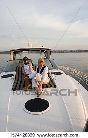 Stock Photo - Friends relaxing on the deck of a boat. Fotosearch
